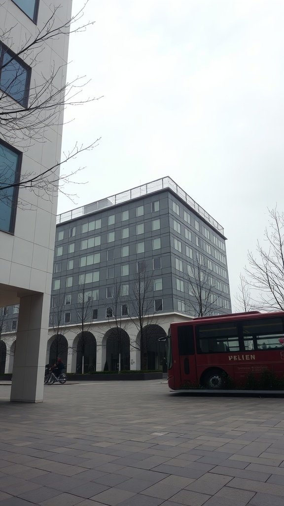 A modern building with a bus in front and trees lining the pathway.